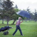 Golfer on a Rainy Day Leaving the Golf Course