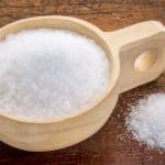 Magnesium sulfate (Epsom salts) in a rustic wooden scoop - relaxing bath concept