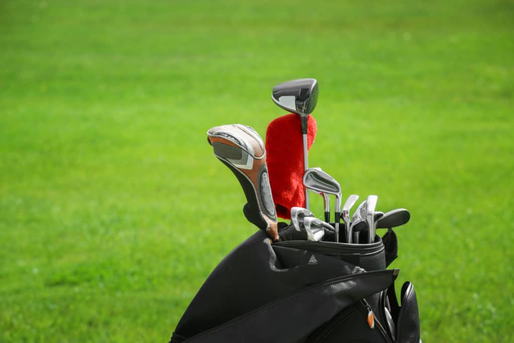 Bag with drivers on golf course, closeup