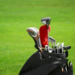 Bag with drivers on golf course, closeup