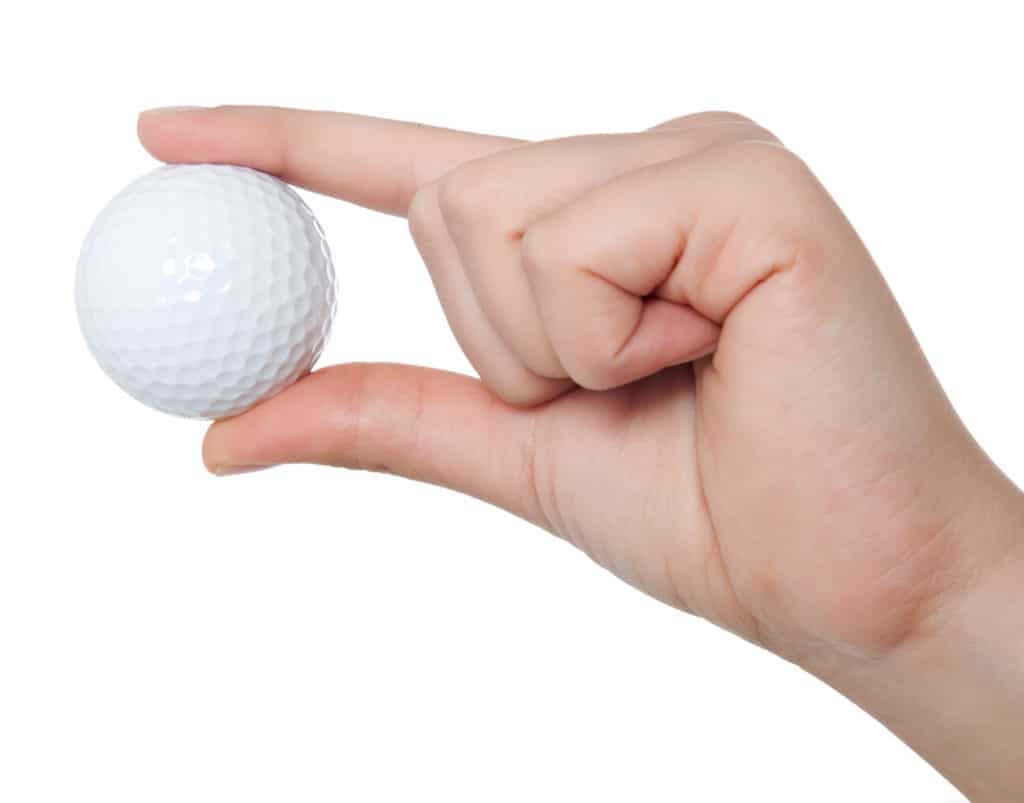 Golf ball hold by a woman hand