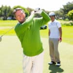 Golfing friends teeing off at the golf course