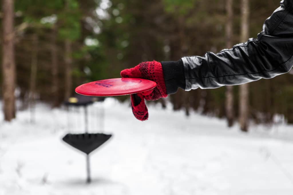 Man playing disc golf in winter time