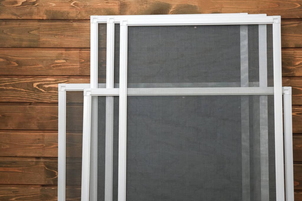 Mosquito window screens on wooden background