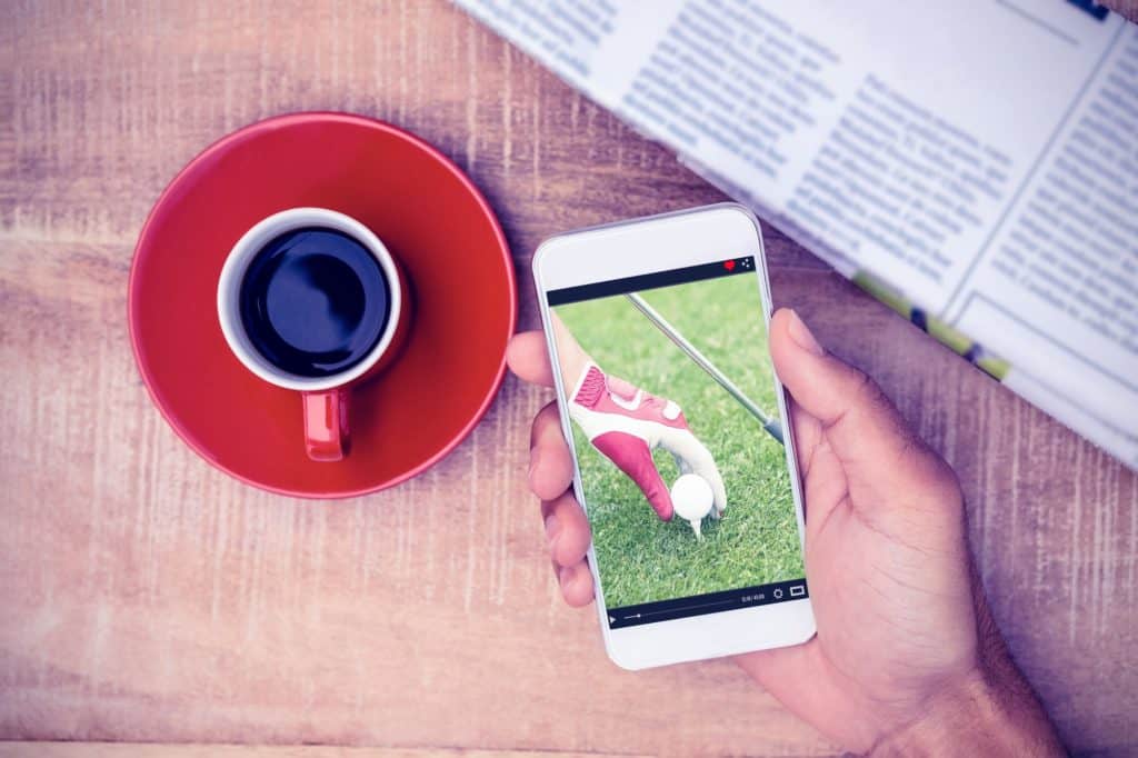 View of lecture app against overhead view of person using smart phone by coffee