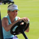 Smiling ladies pro golfer Daniella Montgomery behind steering wh