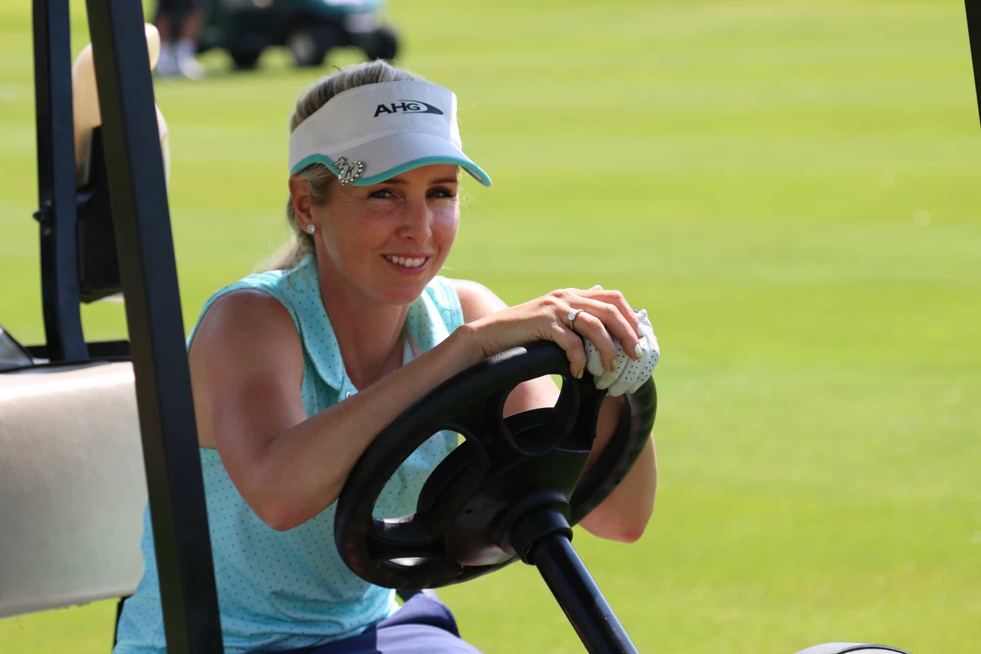 Smiling ladies pro golfer Daniella Montgomery behind steering wh