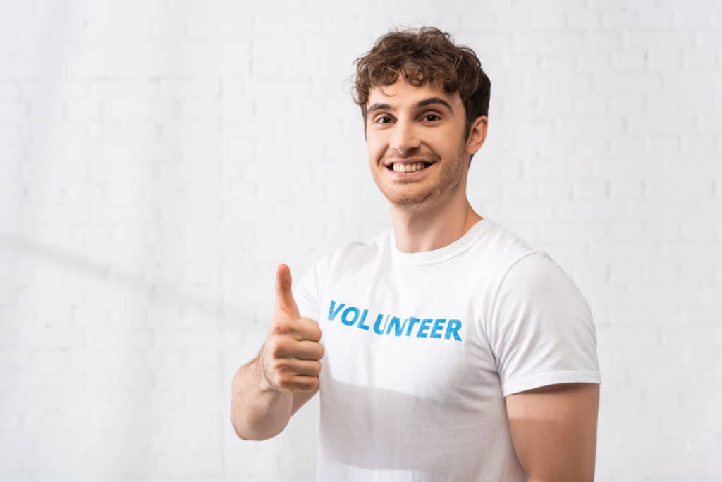 Young man in t-shirt with volunteer lettering