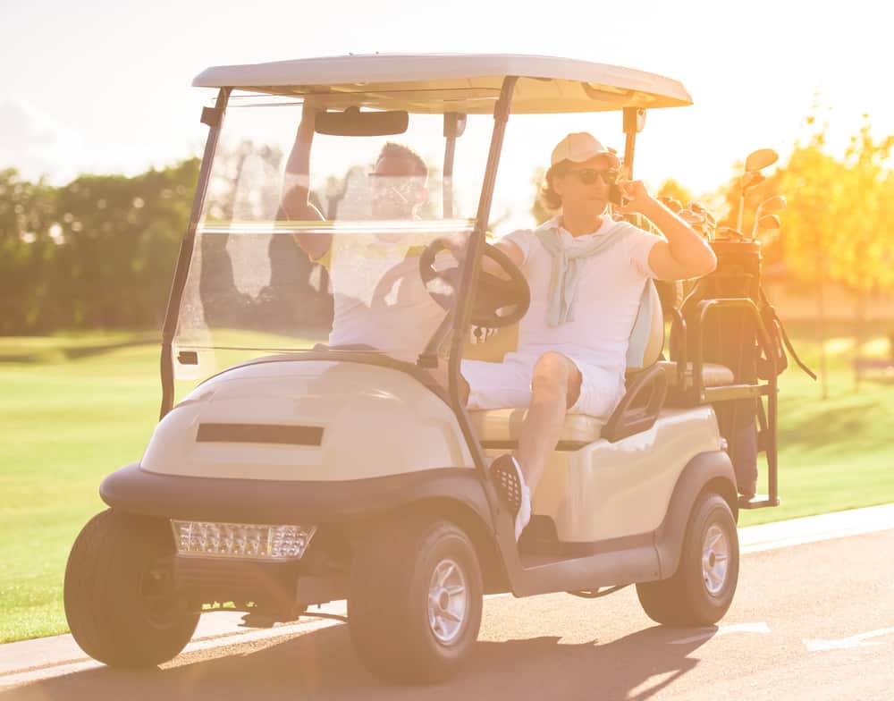 Handsome men are driving a golf cart