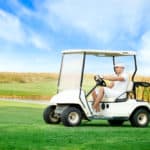 Young man driving golf buggy on golf course
