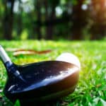 Blurred golf ball and golf club in beautiful golf course