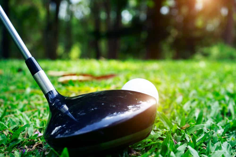 Blurred golf ball and golf club in beautiful golf course