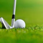 Golf ball and iron on the grass