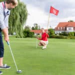Male golf player putting on green 18 hole
