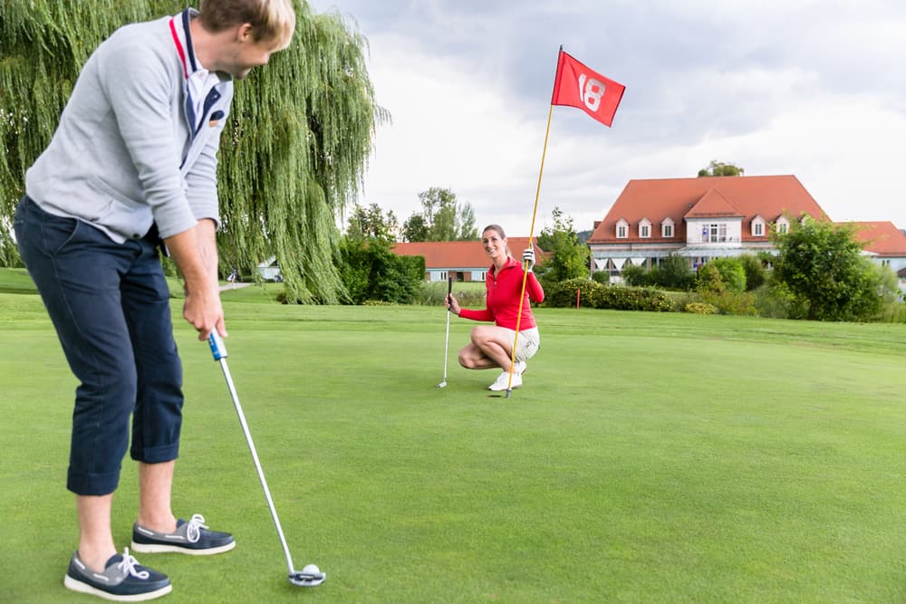 Male golf player putting on green 18 hole