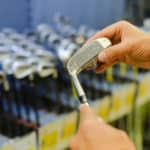 Person holding in hand club at a golf shop