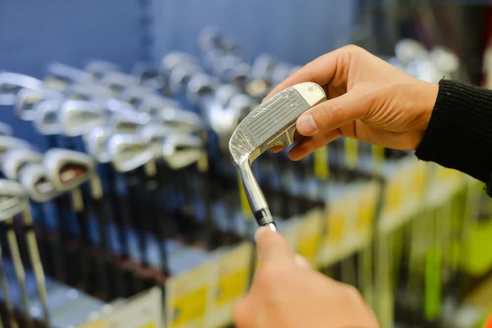 Person holding in hand club at a golf shop