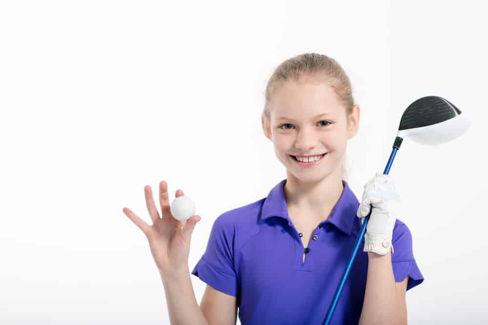 Pretty girl golfer posing with golf club