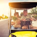 active elderly senior couple getting groceries on golf cart