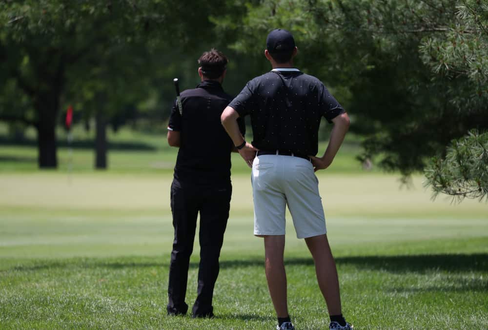 golfer and caddie work together