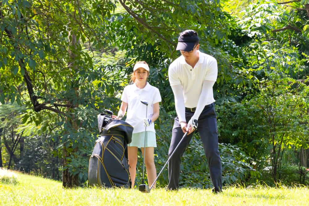 young businessman and caddy playing golf