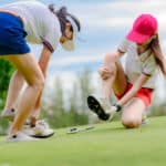 young woman golf player feel uncomfortable in wear of shoe