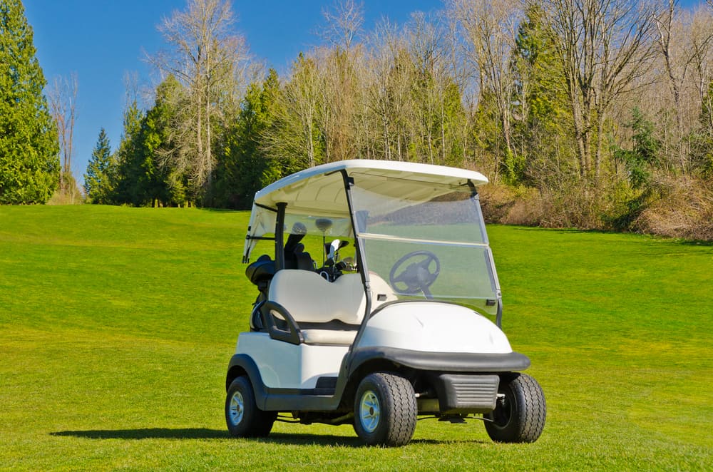 Golf cart over nice green and blue sk