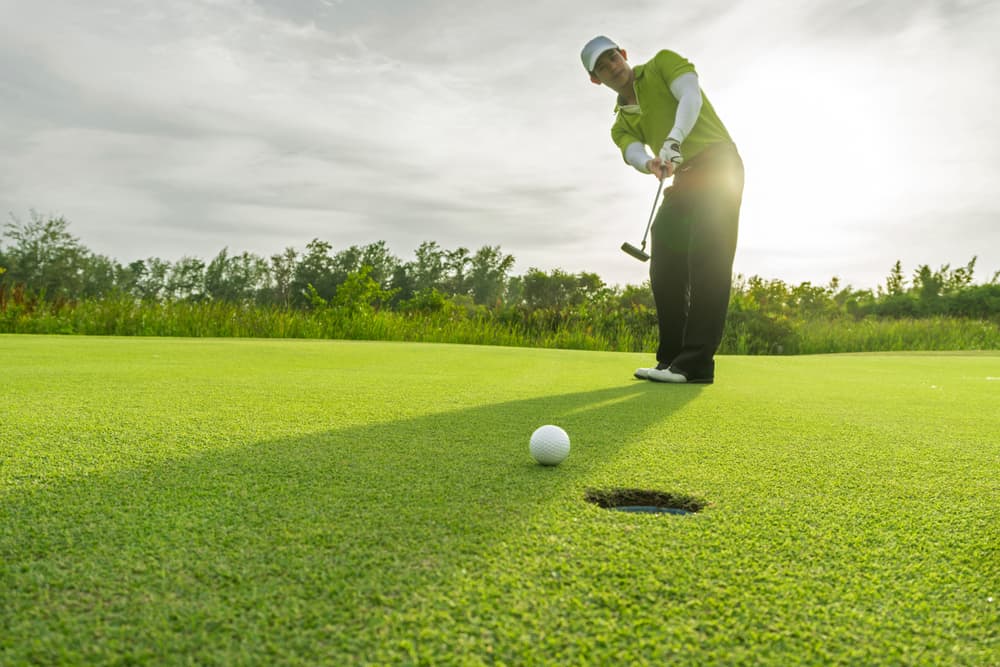 Golfer short putting golf ball