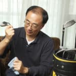 Man cleaning his golf clubs at home