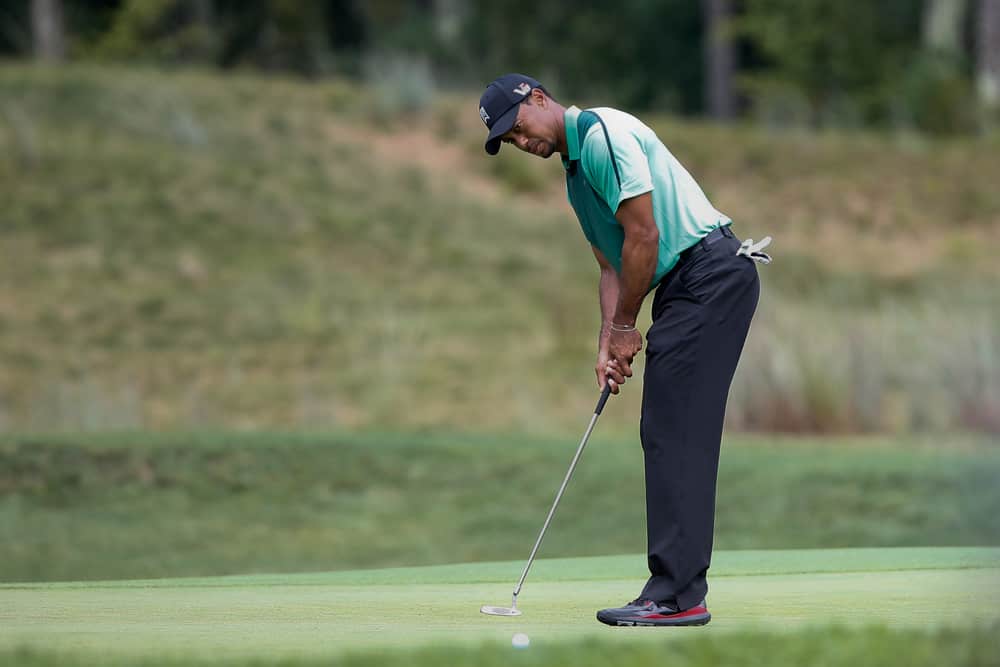 Tiger Woods putts the fourth green