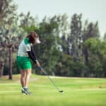 Woman golfer with a golf club on the tee box