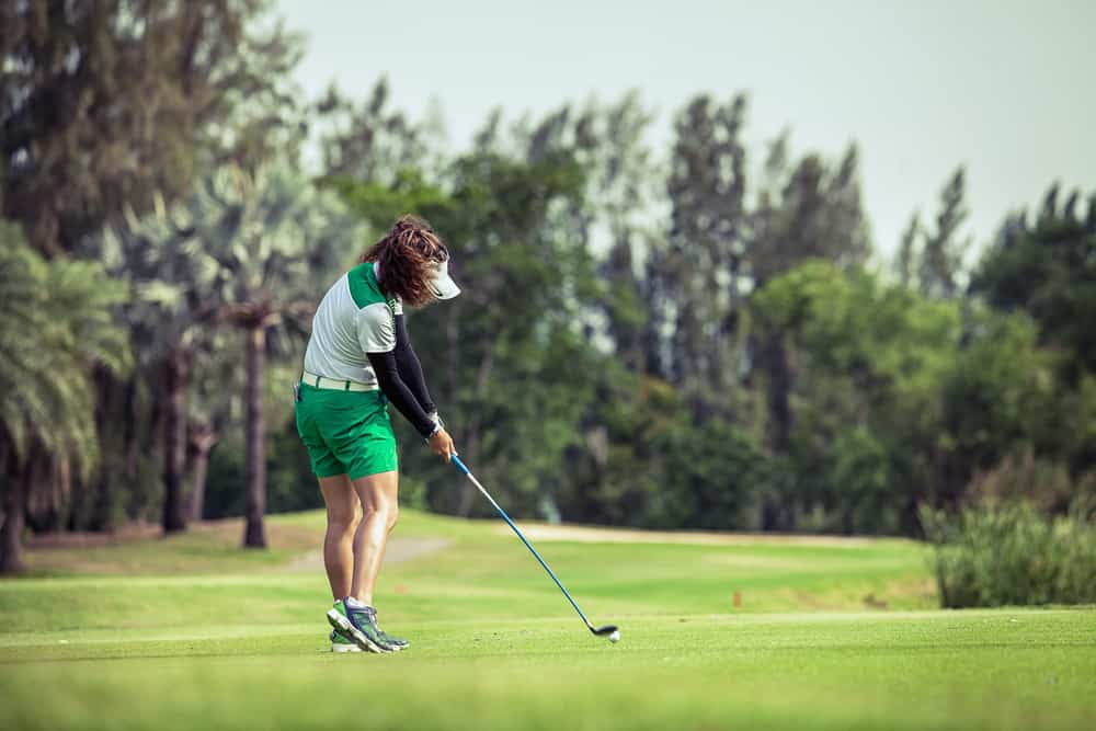 Woman golfer with a golf club on the tee box