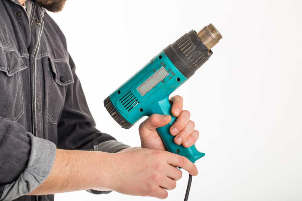 man holding up a heat gun