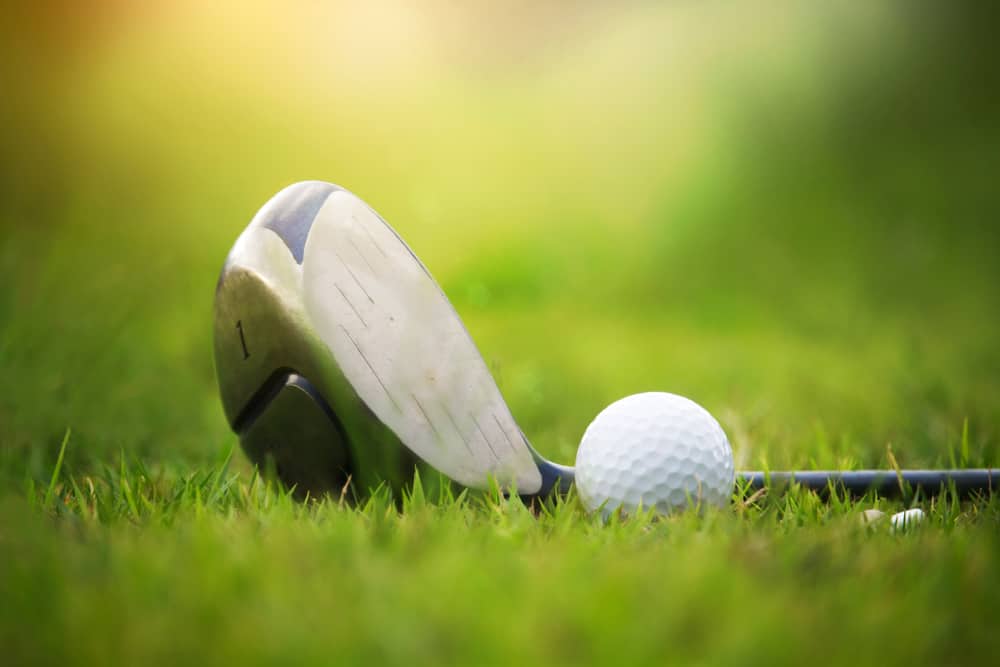 Golf clubs and golf balls on a green lawn