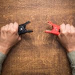 Hands holding car battery charging clamps
