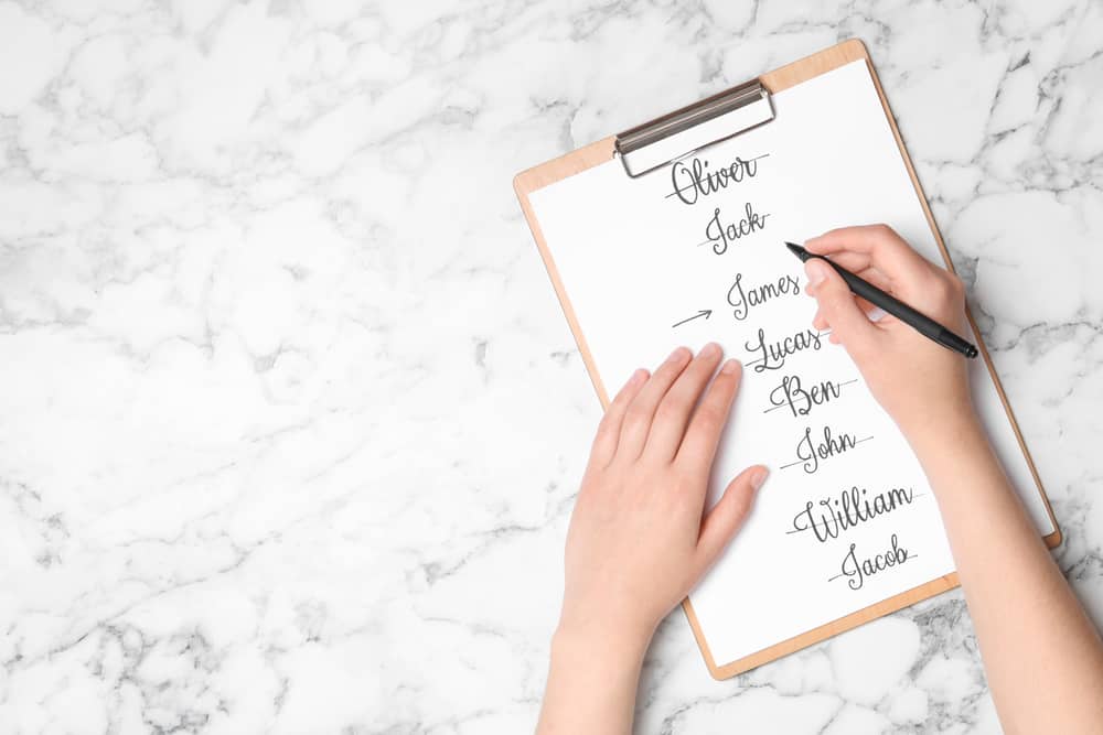 Woman choosing baby name at white marble table