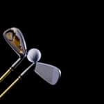 Golf club and golf ball on a black background