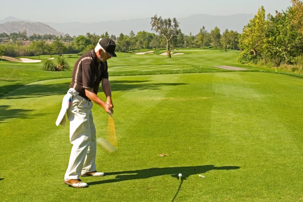 A golf course and senior golfers in action