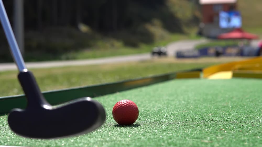 Closeup of player play mini golf with red ball