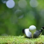 Golf ball on green grass ready to be struck on golf course background