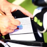 Golfer keeping scores in score sheet with hands