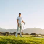 Male golfer holding golf club on field