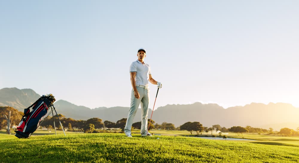 Male golfer holding golf club on field