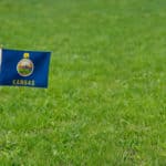 Photo of Kansas state flag on a green grass