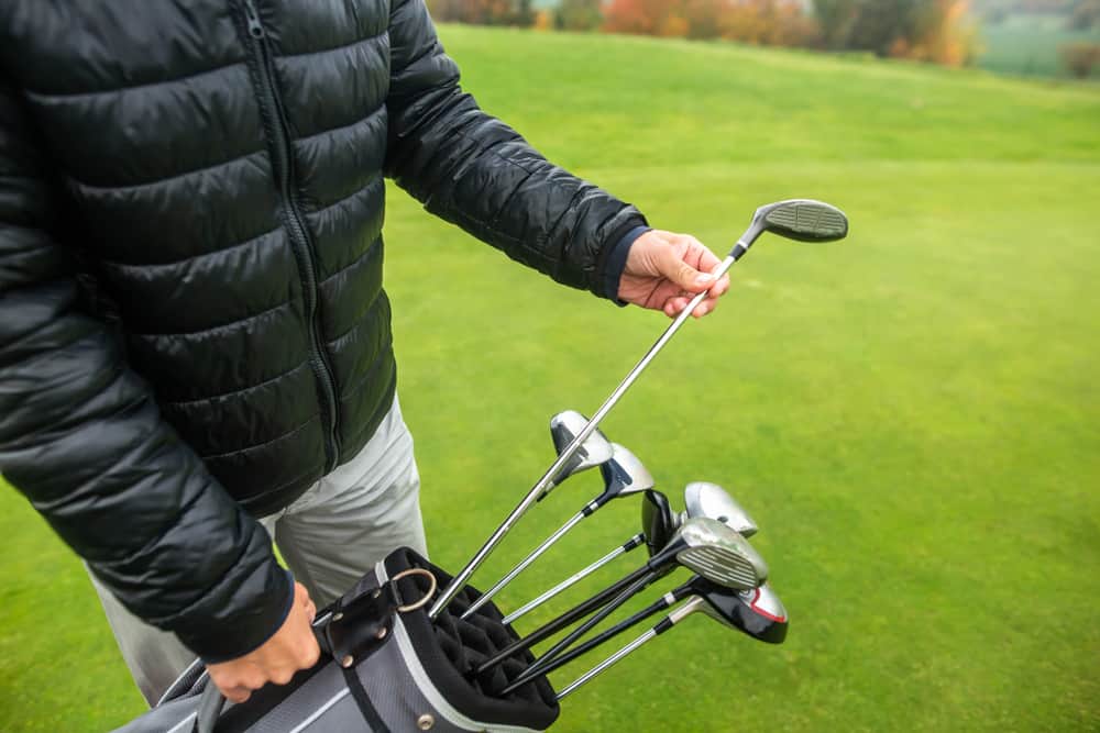 Professional golf player choosing the golf club from the bag