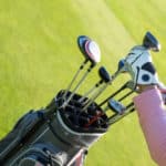 Professional golf player choosing the golf club from the bag