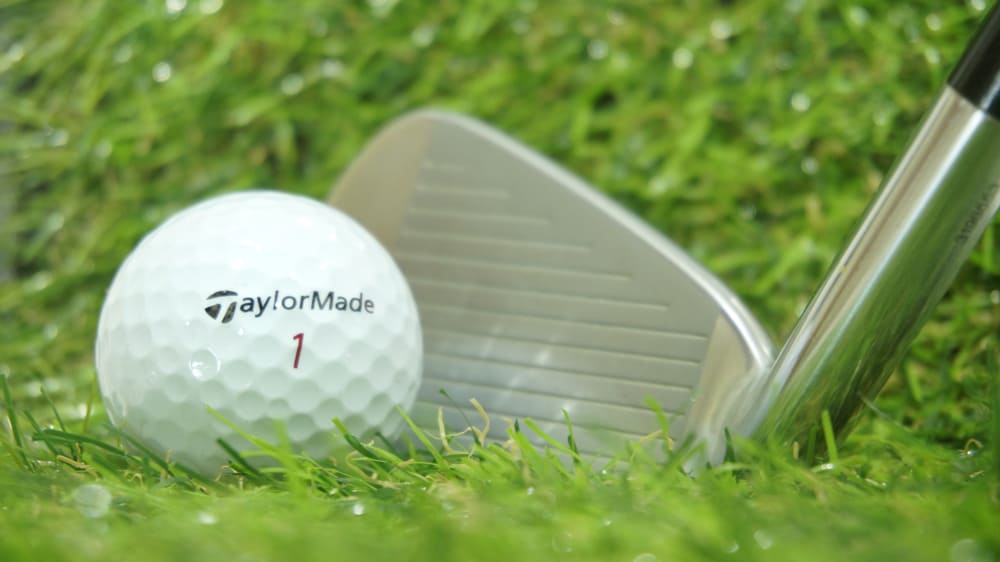 Taylormade golf ball and club on green grass