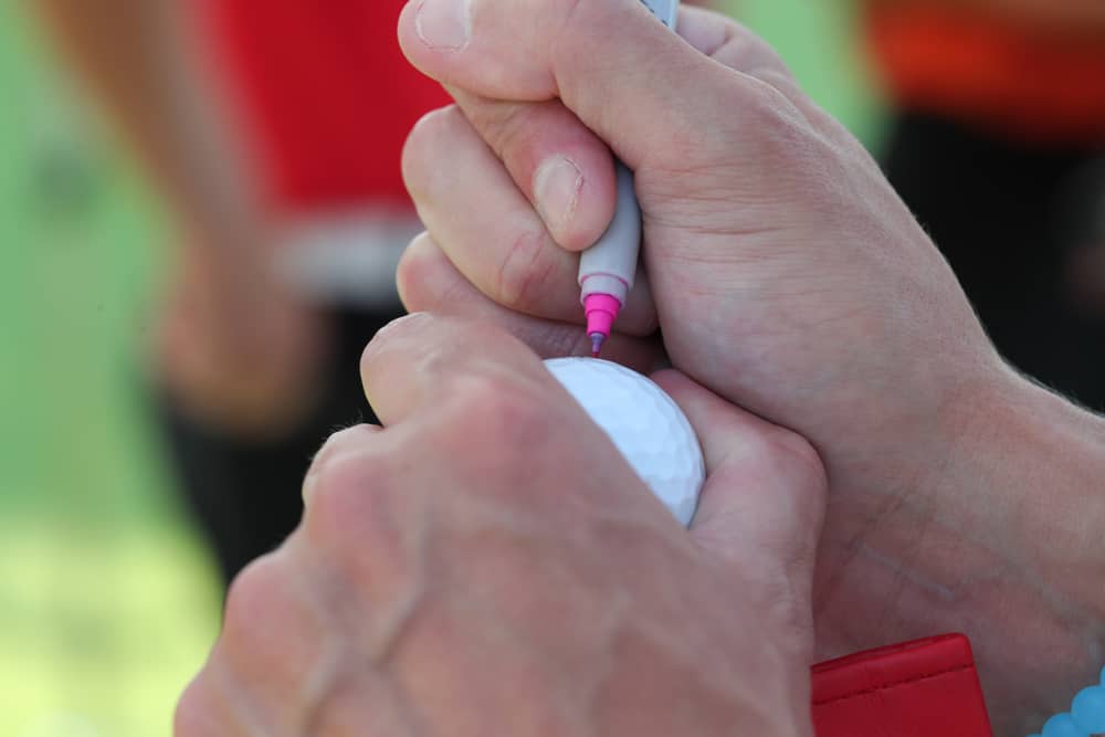 golfer marks his ball