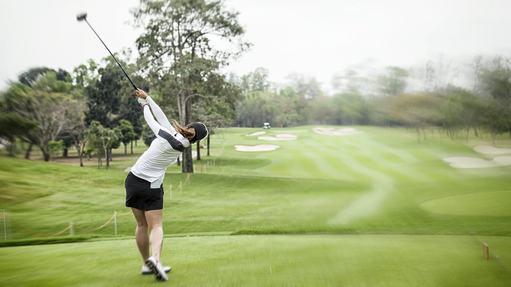 lady golf swing on golf course