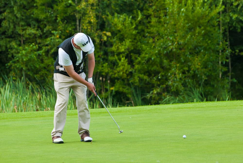 unidentified golfer finishes his swing